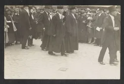 Kirchenpräsident Wurth im Talar und mit Amtskreuz (li.)  u. a. Teilnehmer*innen der Stockholmer Weltkirchenkonferenz laufen durch ein Spalier zum Gottesdienst (Aug. 1925)